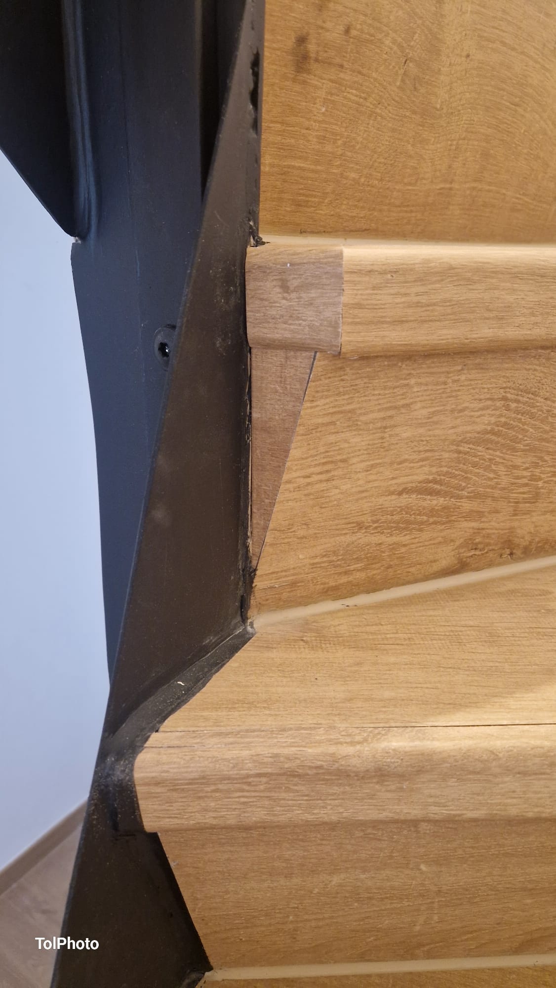 After — Clean oak stair tread with metal edge trim