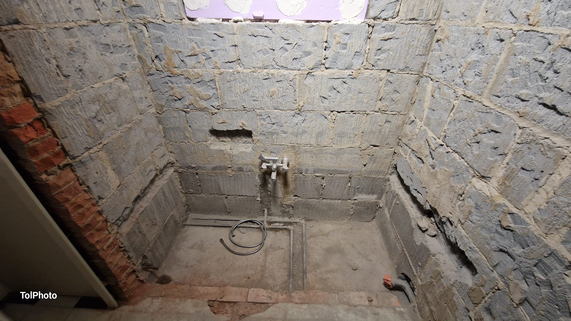 Before — Bare brick walls with exposed plumbing